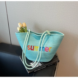 Close-up of woven tote bag with colorful summer embroidery and sturdy rope handles