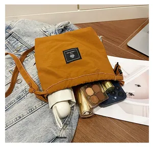 Spacious interior of yellow nylon crossbody bucket bag showing phone and daily items