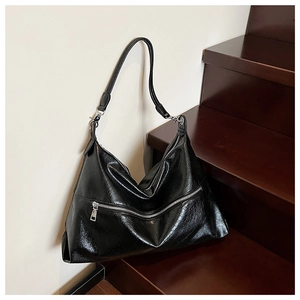 Detailed macro of black glossy PU leather hobo bag with vintage texture and silver zippers