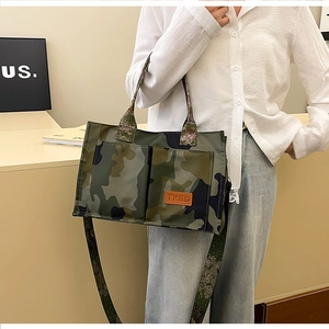 Detail view of camouflage tote bag with front pockets and adjustable crossbody strap