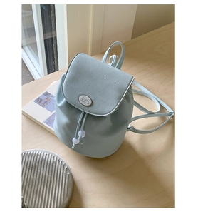 Detailed close-up of light blue mini backpack with lychee grain texture and drawstring