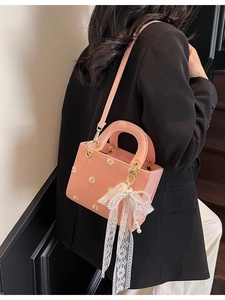 Pink daisy print crossbody bag with lace bow pearl charm and gold handle on model