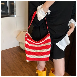Detail of red and white striped woven hobo bag with red leather strap and silver ring buckle