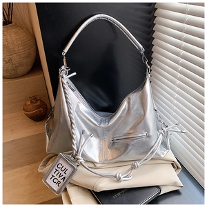 Detailed macro view of metallic silver hobo bag with woven rope and branded square tag