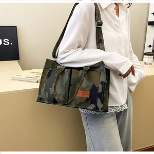 Detailed side view of camouflage tote bag with leather logo and adjustable strap