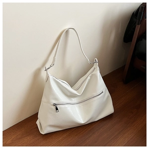 Detail of cream white tote bag featuring soft pleated leather texture and silver hardware