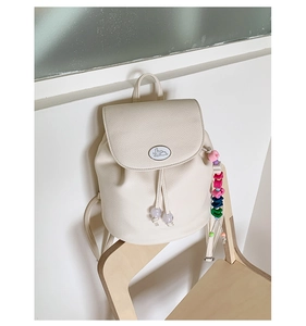 Detail of off-white lychee leather mini backpack with cartoon rabbit and beaded charm
