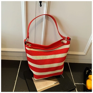 Detail of red and white striped woven tote with leather strap and silver metal ring
