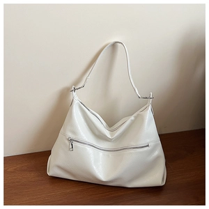 Detailed view of the white glossy texture and metal zipper on the large tote bag