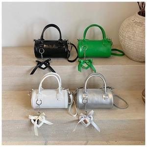 Four vintage cylinder bags in black, green, white, and silver with heart charms