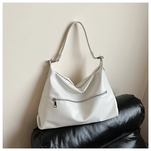 Close-up of the white tote bag featuring natural wrinkled texture and silver metal zipper