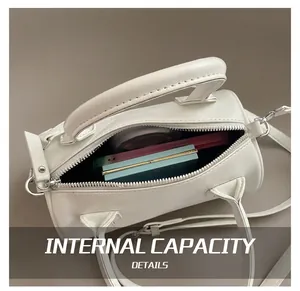 Internal capacity of the white leather barrel bag showing storage for phone and makeup