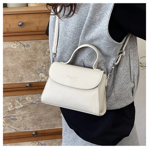 Détail du sac en cuir blanc à motif litchi avec bandoulière amovible et poignée