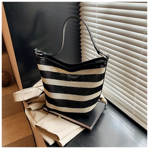 Detail showing woven mesh texture and black leather strap of the striped hobo bag