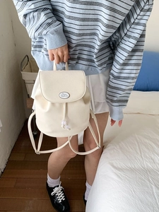 Minimalist beige pebble leather mini backpack with contrast trim and cute rabbit emblem