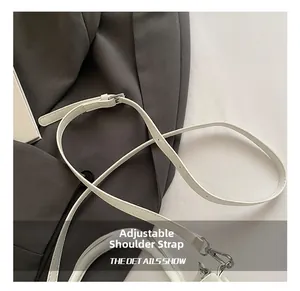 Detail of white leather adjustable shoulder strap with silver metal buckle and lobster clasp