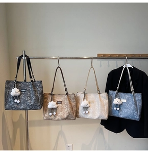 Detail view of large tote bags in four colors with floral jacquard and cloud charms
