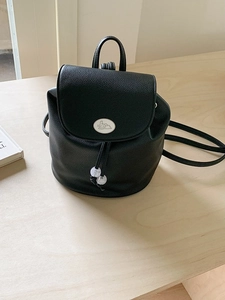 Minimalist black pebbled leather backpack with rabbit logo flap and drawstring closure