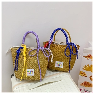 Detail of woven straw tote bags with colored rope handles and drawstring lining
