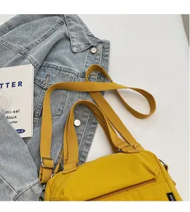 Détail du sac bandoulière en nylon jaune gingembre avec sangle en toile réglable