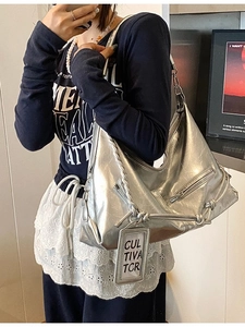 Silver metallic large hobo bag with pleated texture and woven strap shown on shoulder