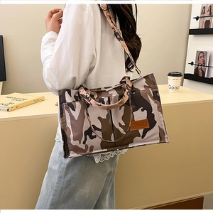Detailed side view of camouflage tote bag showing side pockets and adjustable strap