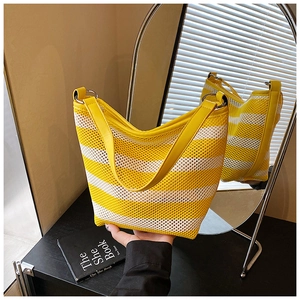 Detail view of yellow striped mesh hobo bag with leather strap and metal ring