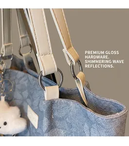 Detailed macro view of blue jacquard fabric tote with white leather handles and cloud charm