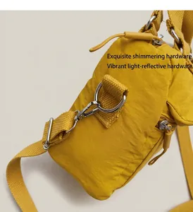 Détail d'un sac à bandoulière en nylon jaune avec ferrures argentées et fermoir à ressort