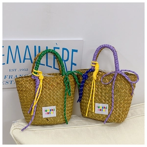 Detail of woven straw handbags with colorful rope handles and brand labels on cushions