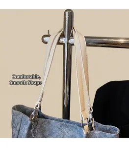 Detail of blue denim tote bag with chic white leather straps and silver metal hardware