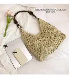 Detail of bohemian straw hobo bag with unique wooden bead strap and large capacity