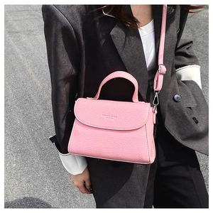 Détail du sac à main rose fuchsia en cuir grainé avec poignée et bandoulière réglable