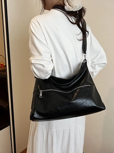 Minimalist large black leather hobo bag with vintage texture and silver zipper detail