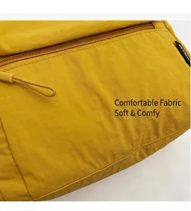 Détail du sac à bandoulière en nylon jaune avec fermeture éclair et texture de tissu doux