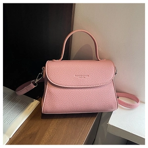 Détail du sac carré en cuir rose texturé avec ferrures argentées et bandoulière amovible