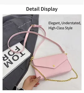 Detailed view of pink pebble grain envelope crossbody bag with gold chain and round buckle