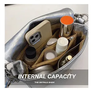 Detail view of the silver metallic crossbody bag interior with multi-compartment organizer