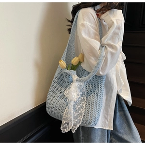 Detail of light blue knit tote bag with lace bow and yellow tulip decorations