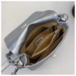 Silver quilted crossbody bag with multi-layer interior and chain strap detail