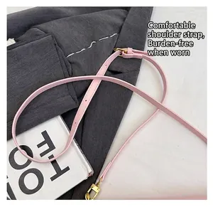Detail of light pink pebbled leather strap with adjustable golden metal buckle and hooks