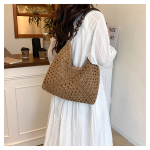 Detail of hand-woven hollow straw hobo bag with unique decorative wooden beads shoulder strap
