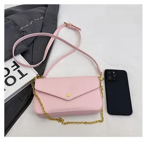 Detailed size comparison of pink envelope crossbody bag with a mobile phone and strap