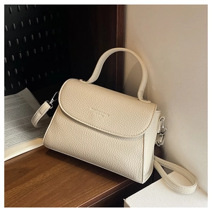 Détail de la texture cuir grainé blanc crème sur un sac à bandoulière tendance chic
