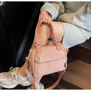 Détail d'un sac à main en nylon rose poudré avec bandoulière réglable