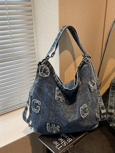 Vintage dark blue washed denim hobo bag with frayed letter patches and crossbody strap
