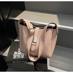Détail du sac seau en cuir rose grainé avec boucle en métal argenté élégante