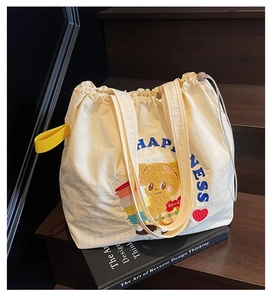 Detail of cute bear embroidery and blue Happiness text on large off-white tote bag