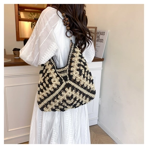 Detail of hand-crocheted woven shoulder bag with geometric patterns and wooden bead strap