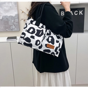 Detail of printed cow pattern tote bag showing high-quality canvas and leather logo patch